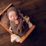 Beautiful Newborn baby boy posed in a wooden crib by newborn photographer in Norfolk