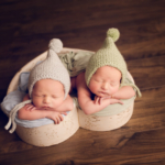 Beautiful Newborn twin boys posed in a heart shaped bowl l by newborn photographer in Norfolk