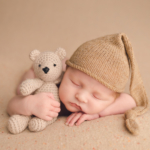 Beautiful Newborn baby boy cuddling a teddy bear by newborn photographer in Norfolk