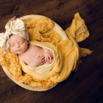Beautiful Newborn baby girl posed in a yellow bowl by newborn photographer in Norfolk