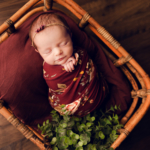 Beautiful Newborn baby girl posed in a basket by newborn photographer in Norfolk