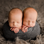 Beautiful Newborn twin boys wrapped together in a grey shawl by newborn photographer in Norfolk