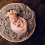 Beautiful Newborn baby girl posed in a pink bowl by newborn photographer in Norfolk