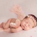 Beautiful Newborn baby girl posed on a rosebud blanket by newborn photographer in Norfolk