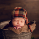 Beautiful Newborn baby boy posed in a bucket by newborn photographer in Norfolk