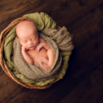 Beautiful Newborn baby boy posed in a wooden bowl by newborn photographer in Norfolk