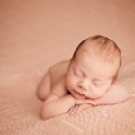 Beautiful Newborn baby girl laying on a pink blanket by newborn photographer in Norfolk