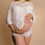 pregnany woman wearing white on a cream background by maternity photographer norfolk
