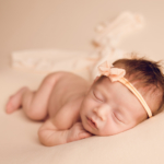 Beautiful Newborn baby girl laying on peach by newborn photographer in Norfolk