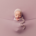 newborn baby wrapped in lilac with bonnet by newborn photographer norfolk