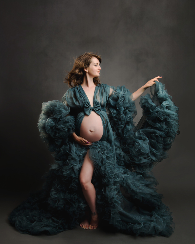 beautiful pregnant woman wearing a blue gown on a grey background by norfolk maternity photographer