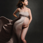 beautiful pregnant woman covered in cream satin