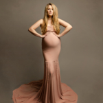 stunning pregnant woman wearing a pink gown on a neural background by maternity photographer in norfolk